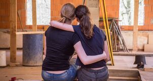 Two women holding each other and sitting on a bench