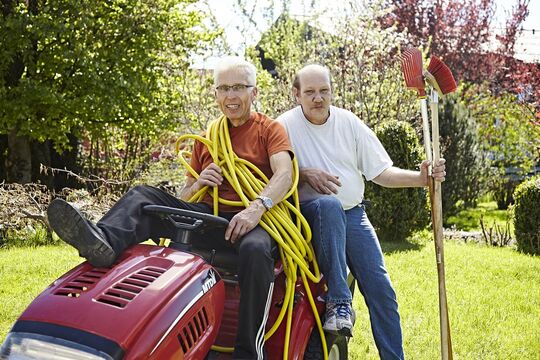 The hotel's janitors pose with brooms, rakes and garden hoses