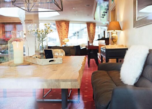 The seating area with the regulars' table seen from outside through a window with the bar and lobby in the background