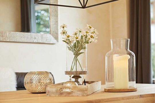 Close-up of the regulars' table with table decorations such as flowers, vases and a large candle on top
