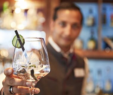 A bartender hands over a prepared glass