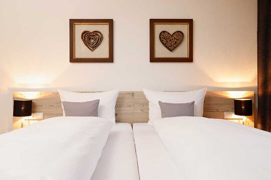 Close-up of the double bed in the bedroom of the vacation apartment with two bedside lights switched on