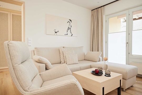 Sofa and TV armchair in light beige with table in the Widderstein double room