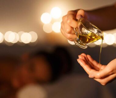 A masseuse pours massage oil into her hand