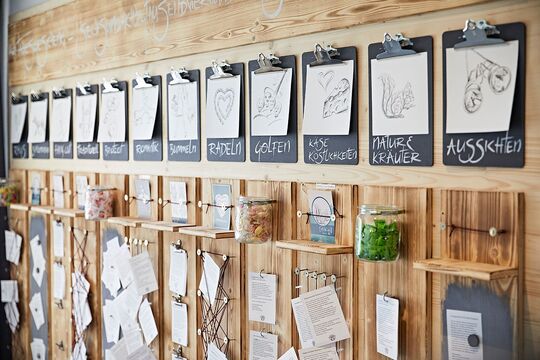A wooden wall with different themed categories that serves as an information wall for guests for activities