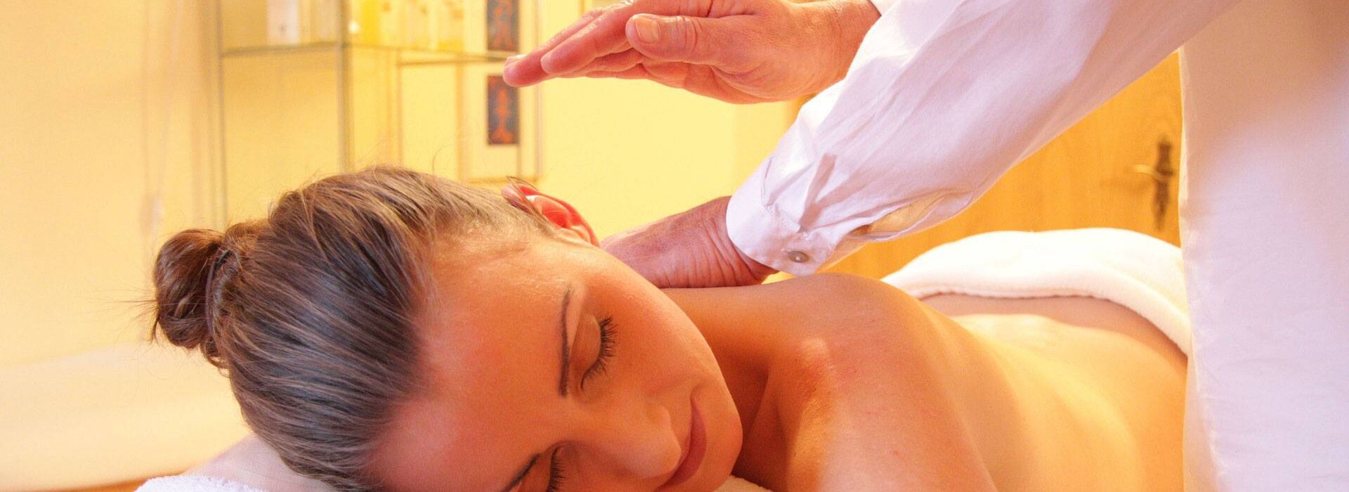 A lady during a back massage by a masseur