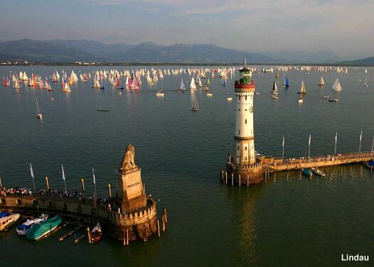 The harbor entrance of Lindau harbor with the lion, lighthouse and a sailing regatta in the background