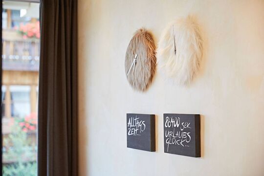 Two wall clocks made of fur hanging next to each other on the wall in a hotel seating area