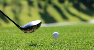 A golf club and a golf ball on a tee