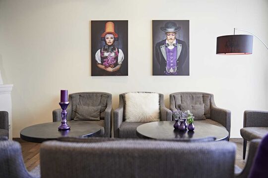 Seating area in the hotel's fireplace room with works of art on the wall
