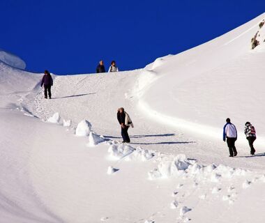Ascent of a winter hiking trail with hikers
