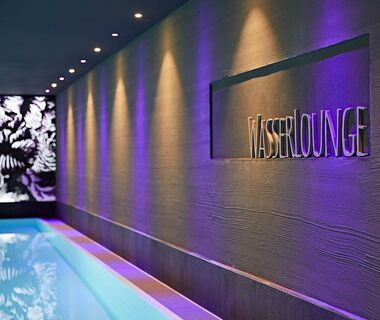 The Water Lounge lettering set into the wall - illuminated by different colored ceiling lights
