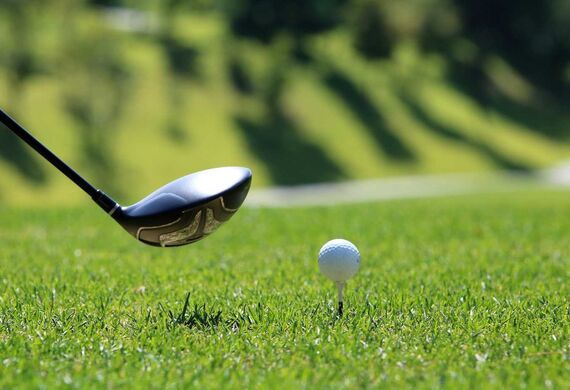 A golf club and a golf ball on a tee